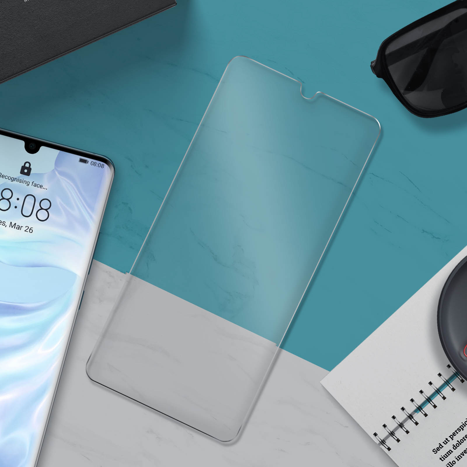 Protezione schermo su un tavolo. Telefono a sinistra. Accessori su sfondo blu.