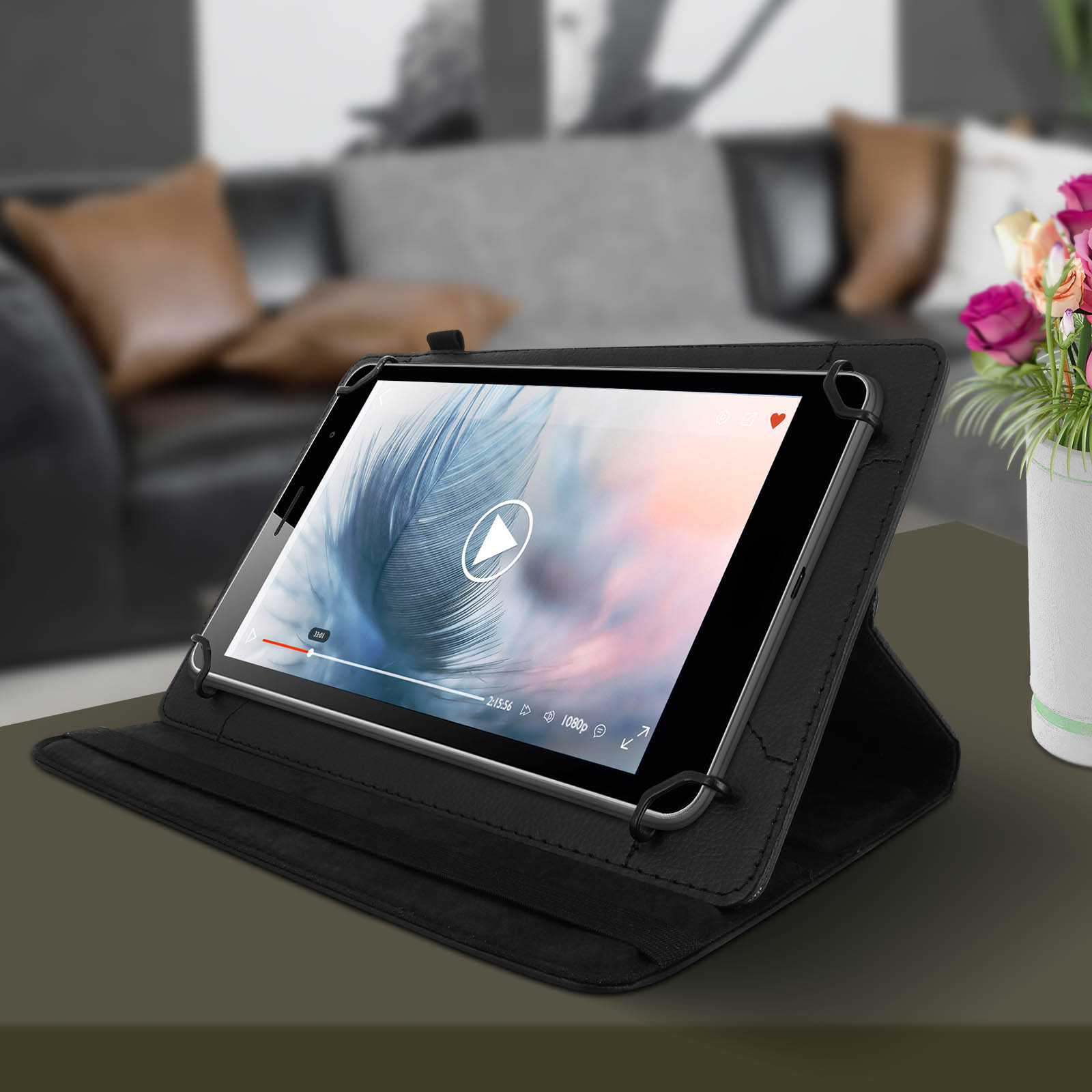 Tablet in custodia nera, mostra un video. Vaso di fiori a destra.