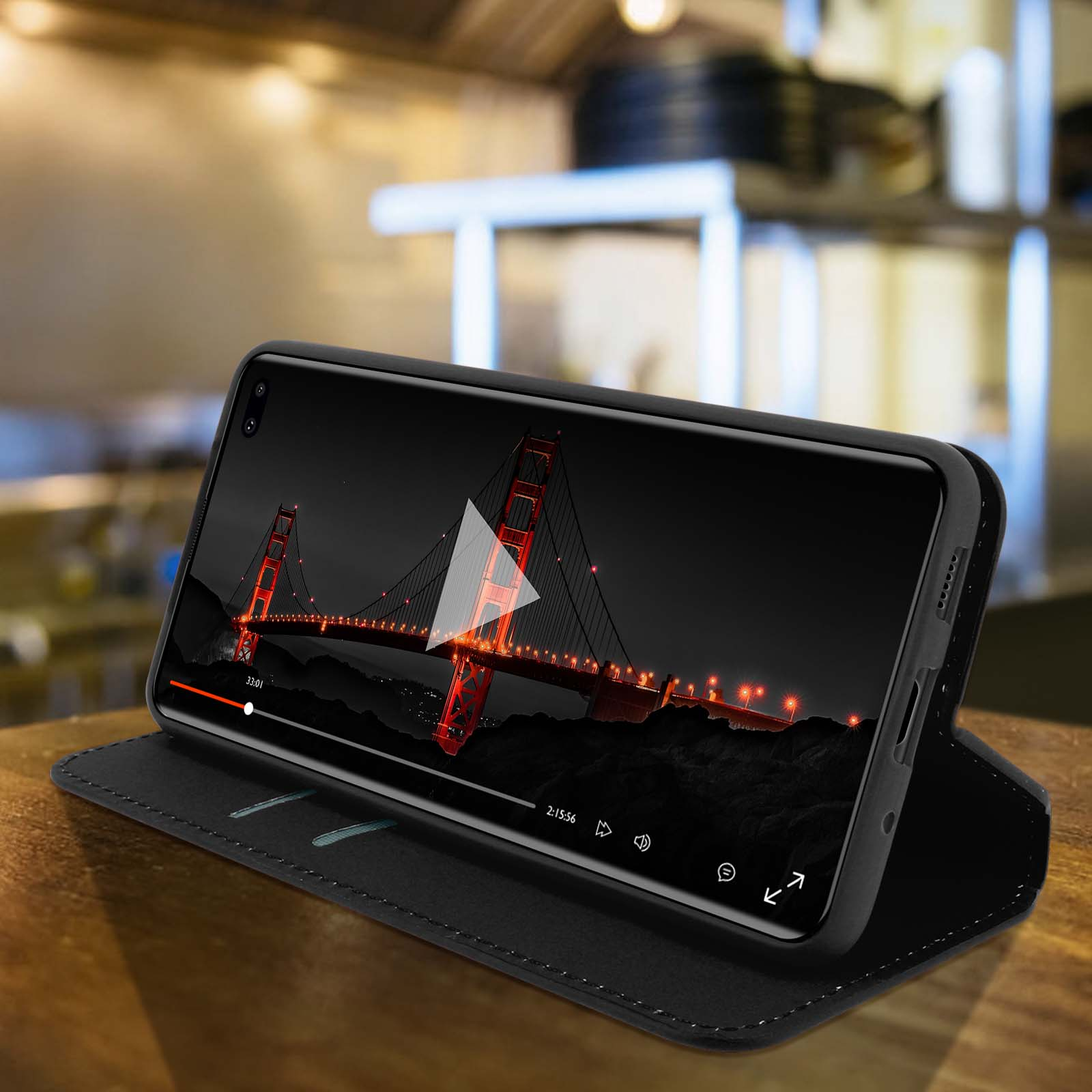 Téléphone noir dans un étui, lisant une vidéo. Le téléphone est sur un étui noir.