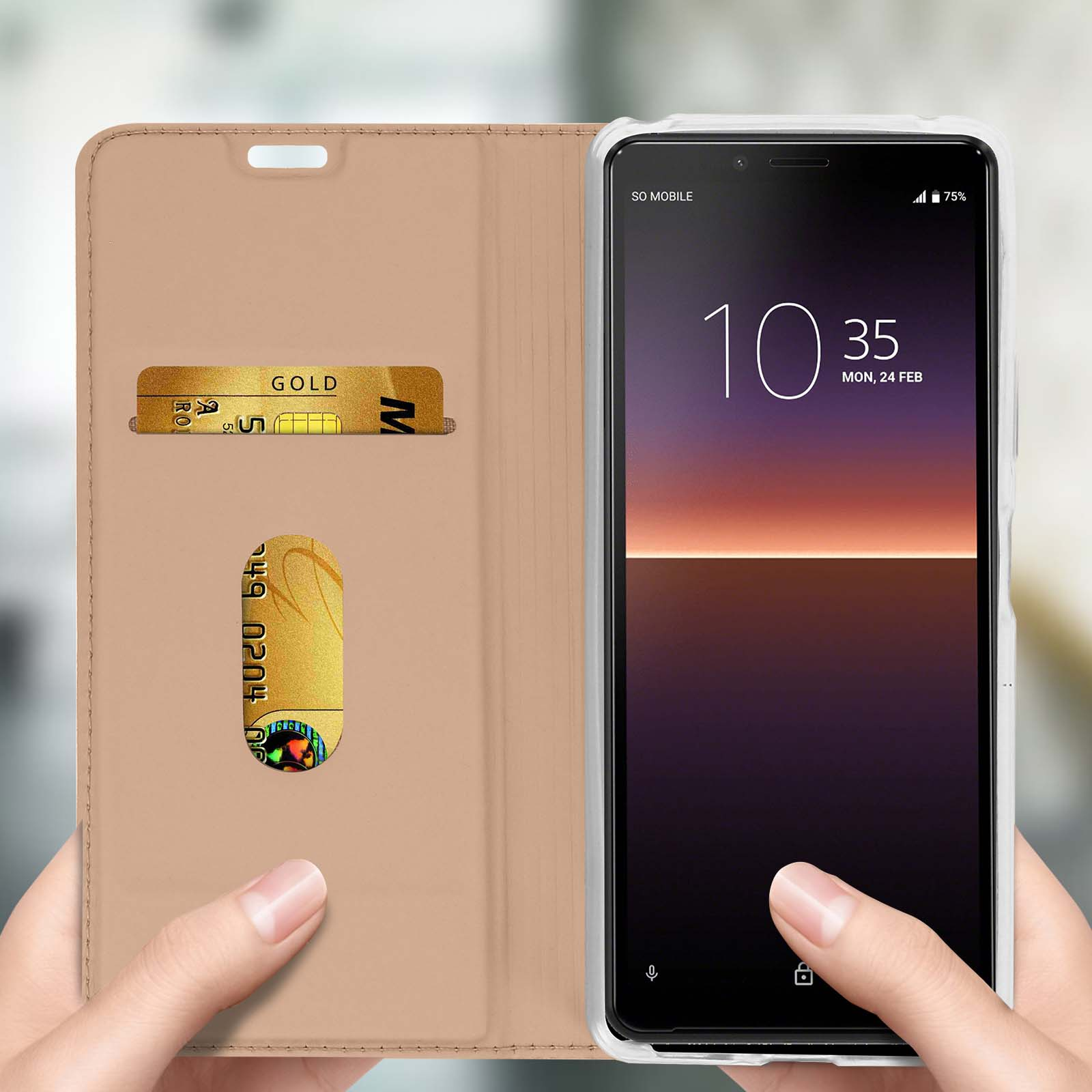 Una custodia per telefono è aperta, mostrando un telefono, fessure per carte e una carta d'oro.