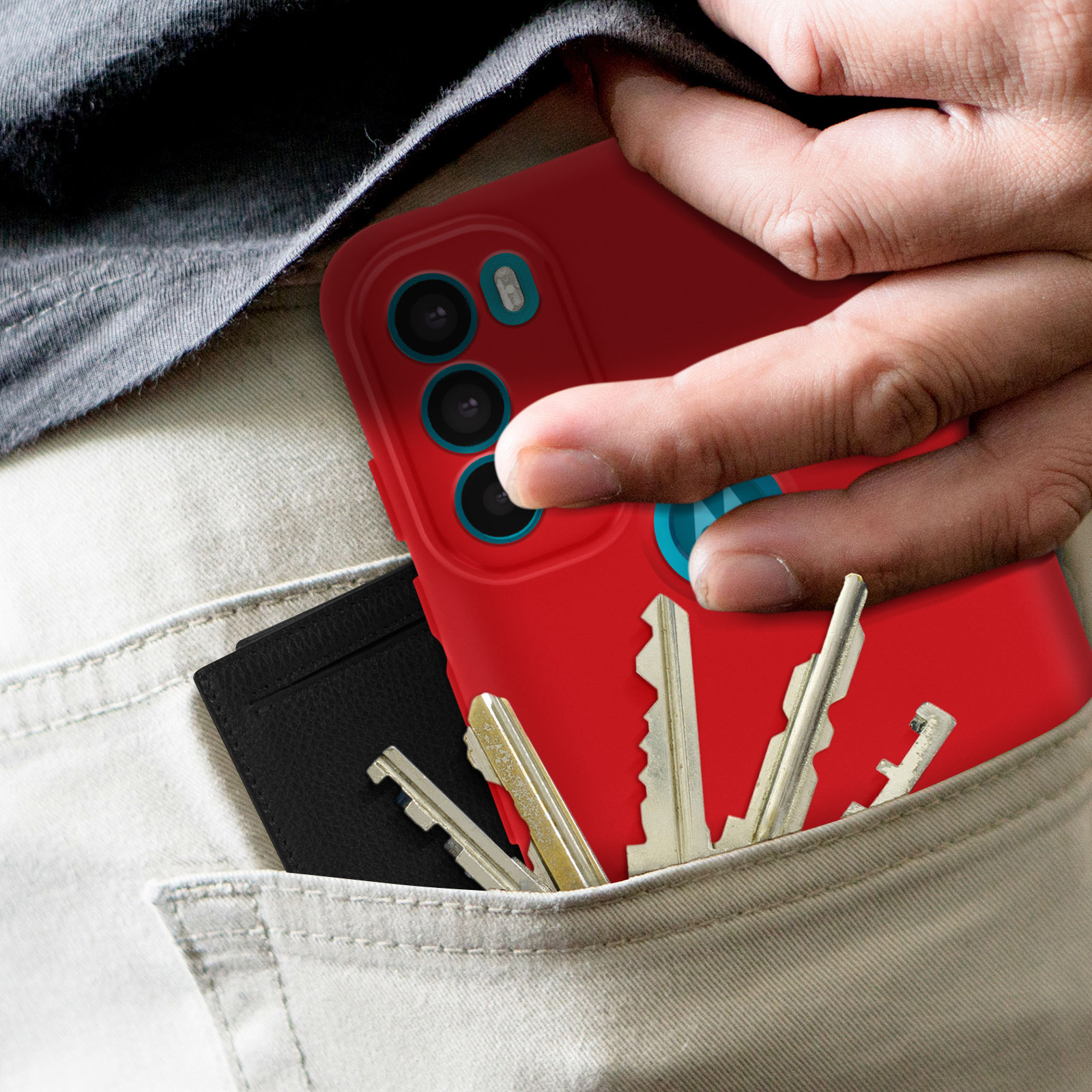 Una mano in tasca, che tiene una custodia per telefono rossa, un porta carte nero e chiavi.