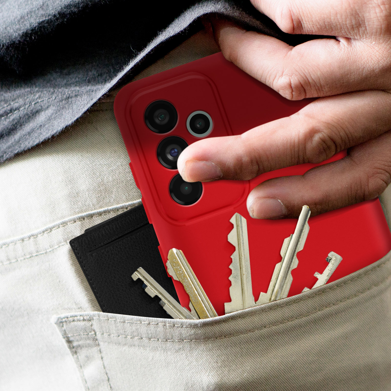 Mano che tiene un telefono rosso in tasca con chiavi e portafoglio.