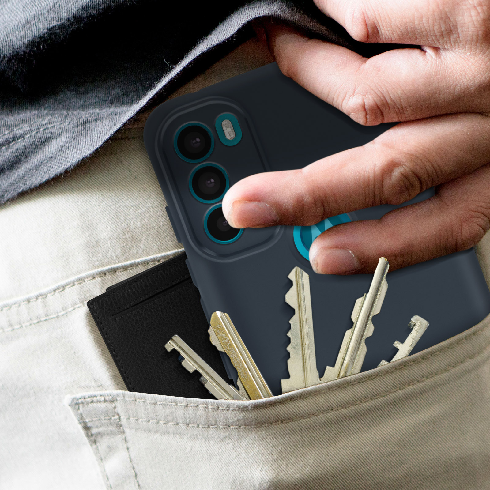 Una mano in tasca con chiavi e un porta carte nero. Anche una custodia per telefono è in tasca.