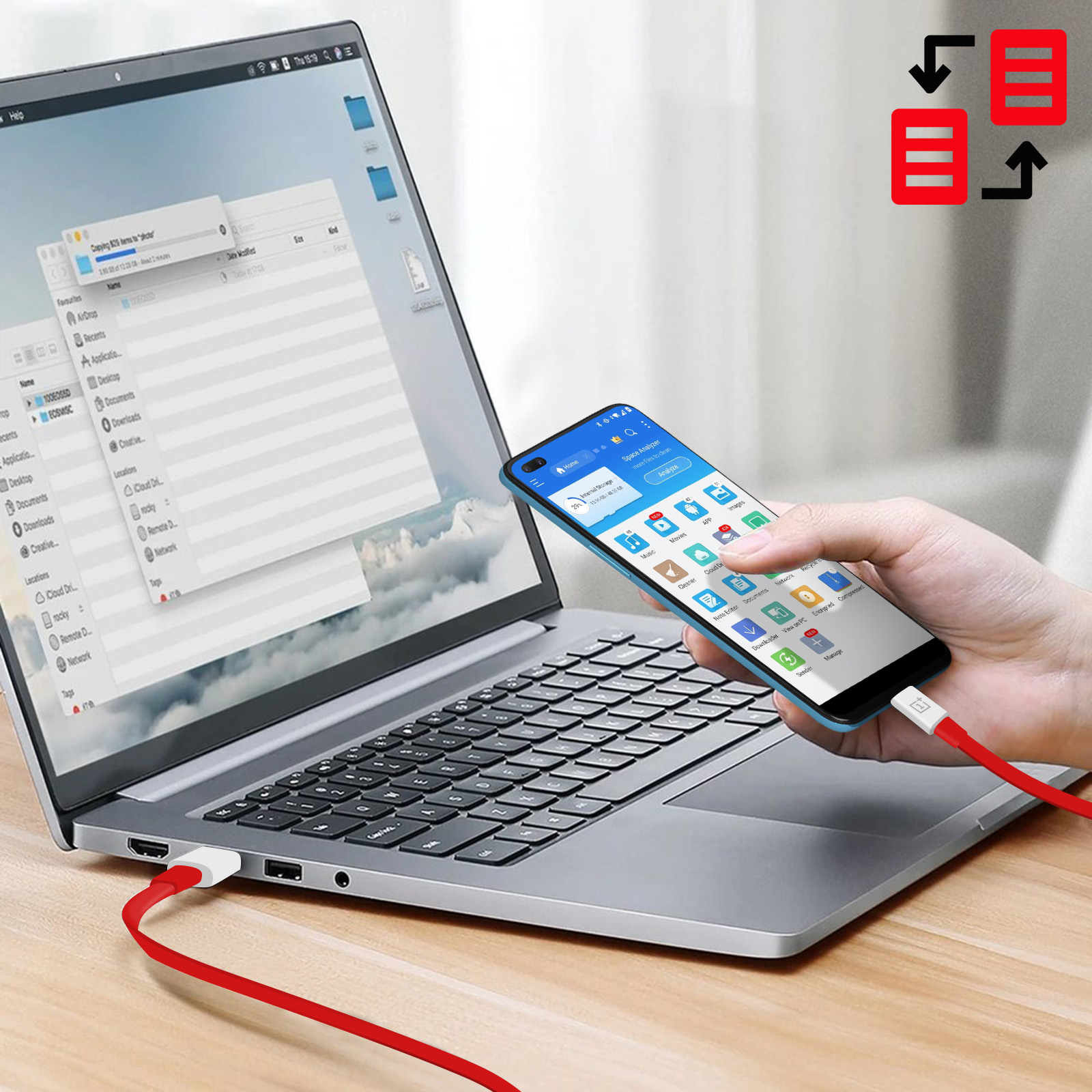 Telefon podłączony do laptopa za pomocą czerwonego kabla. Telefon jest niebieski.