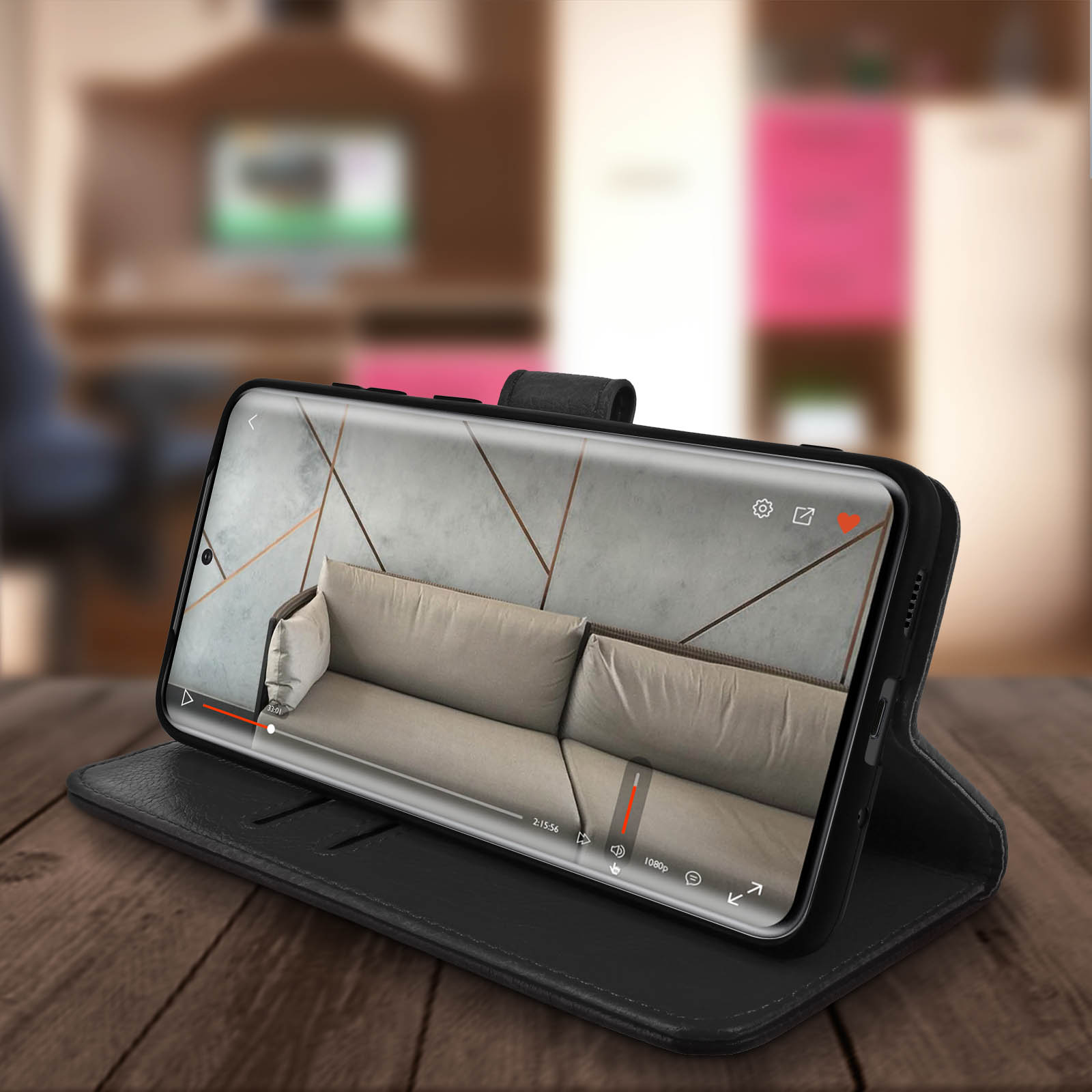 Téléphone noir dans un étui noir lit une vidéo. Il est sur une surface en bois.