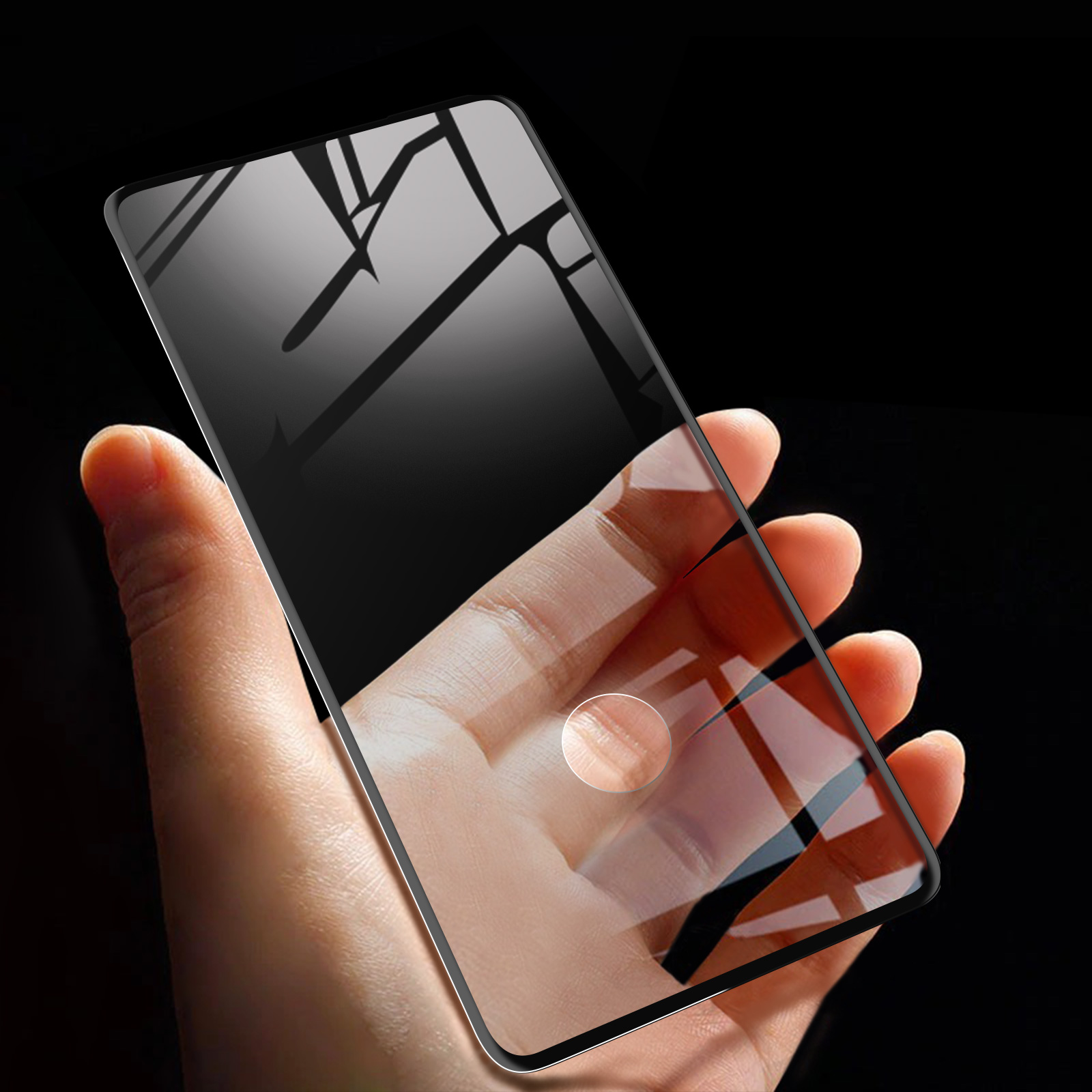 Mano che tiene una protezione per lo schermo del telefono. Sfondo nero con riflessi sulla protezione. Impronta digitale visibile.