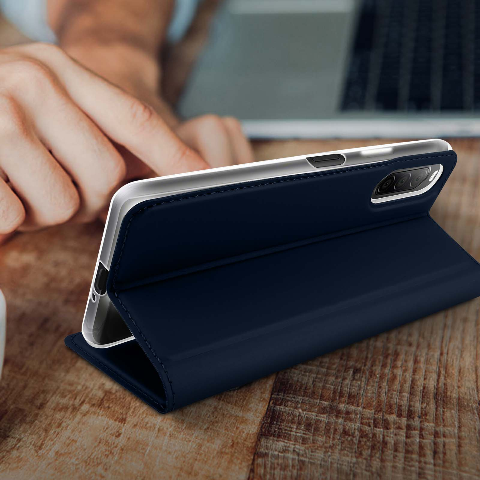 Custodia blu scuro aperta, su tavolo legno. Schermo visibile.
