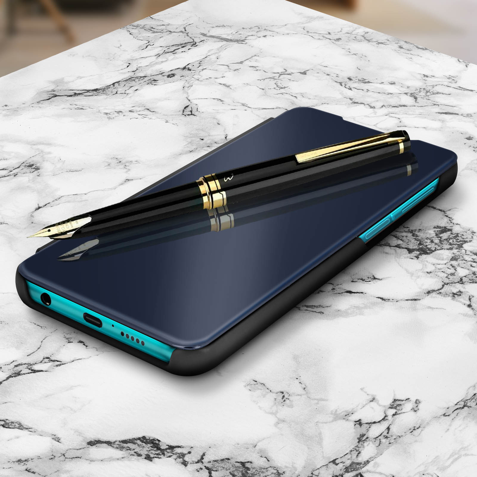 Téléphone dans un étui bleu foncé avec un stylo dessus. Il est sur une surface en marbre blanc.