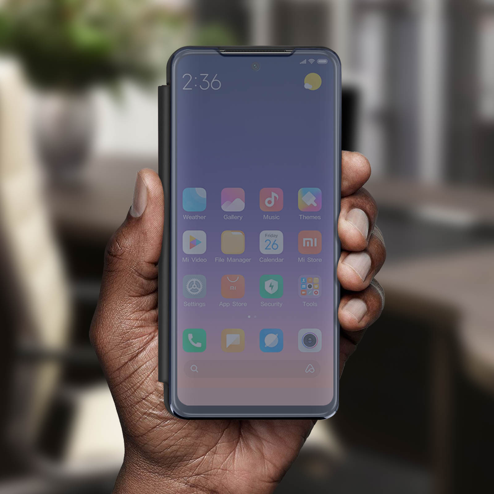 Une main tient un téléphone dans un étui. L'écran affiche l'heure et les icônes d'applications.