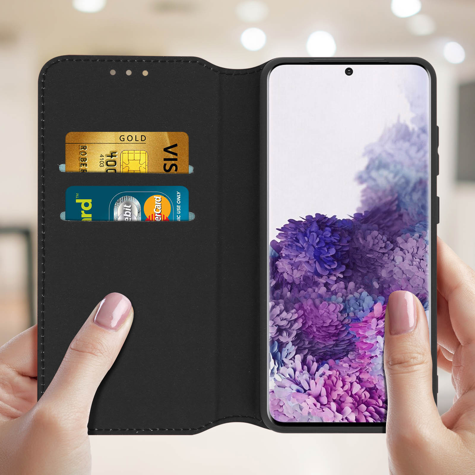 Zwarte telefoonhoes met creditcards. Telefoon toont paarse bloemenafbeelding.