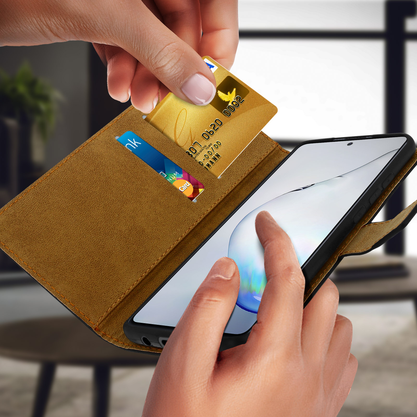 Mano che mette una carta in una custodia a portafoglio per telefono. Lo sfondo è un interno sfocato.