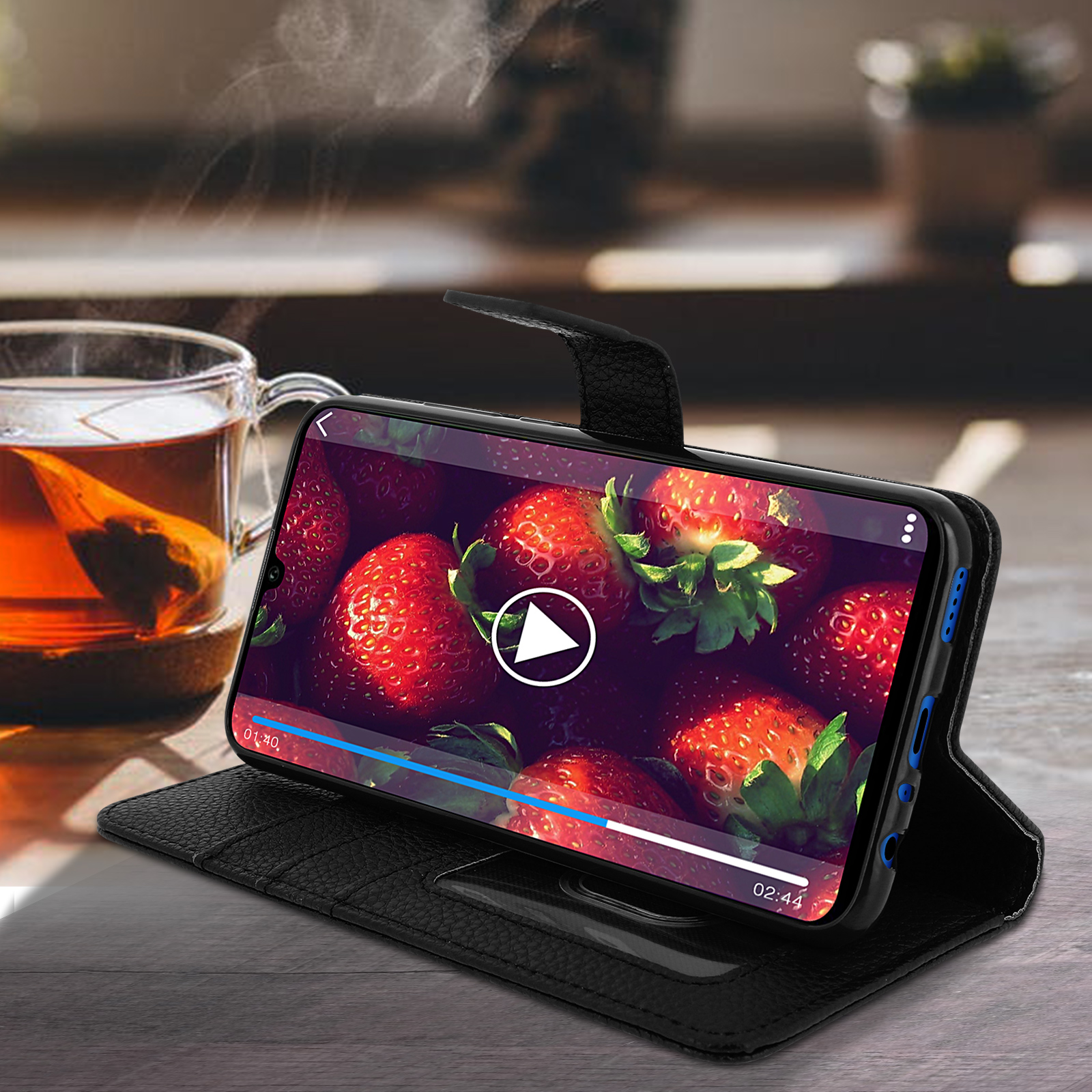 Un telefono in una custodia nera con un video di fragole.