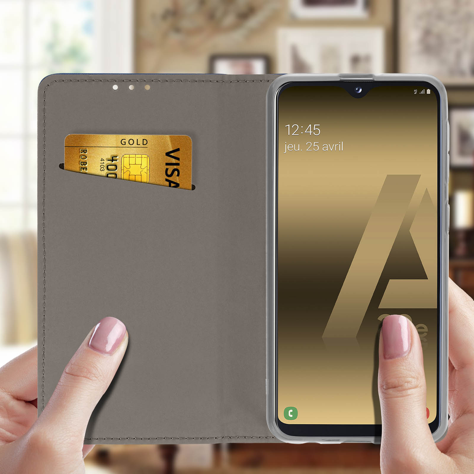 Un téléphone est dans un étui gris avec une fente pour carte de crédit. Une main tient le téléphone, affichant la date.