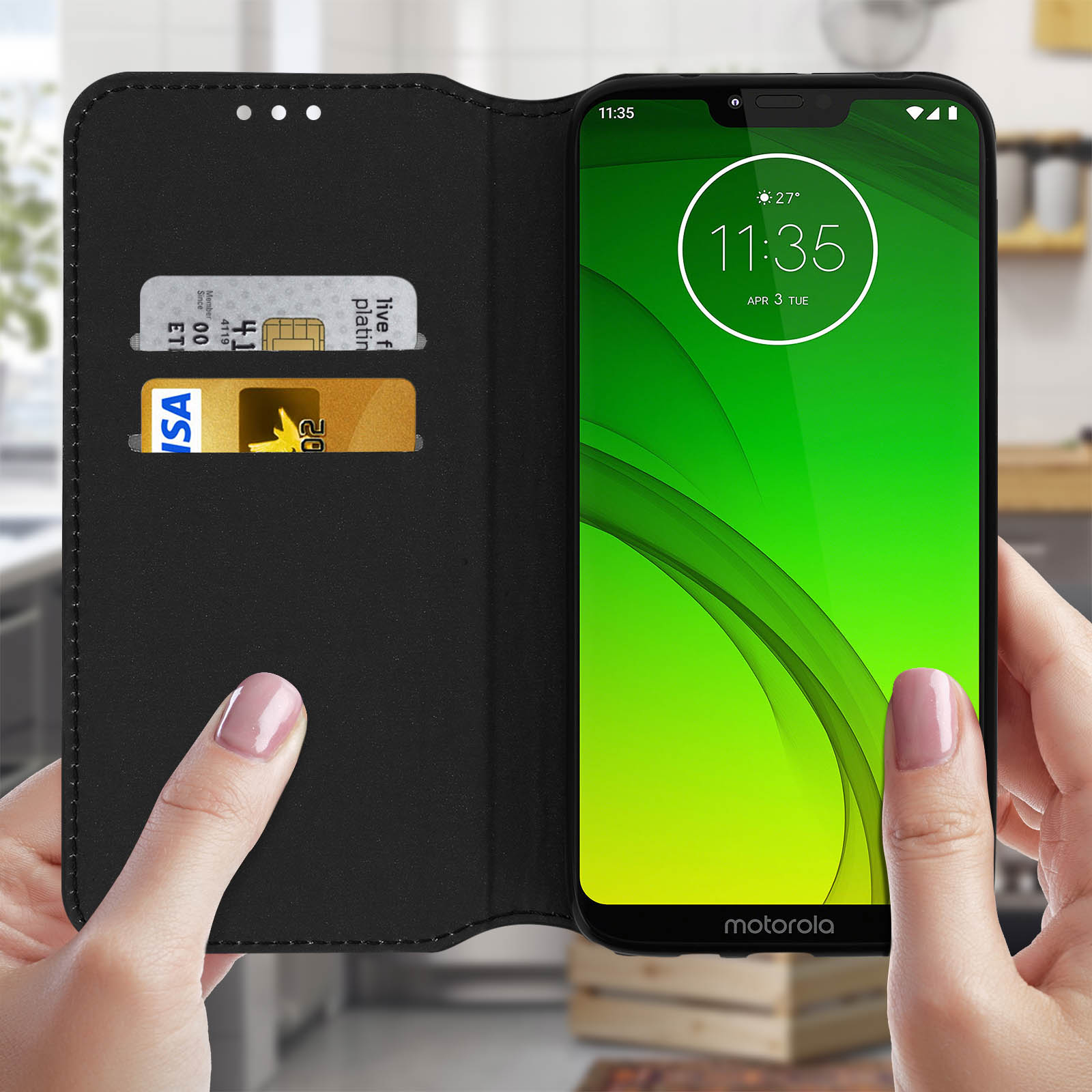 Un telefono nero in una custodia a portafoglio nera è aperto, mostrando l'ora e la data. Lo sfondo è sfocato.
