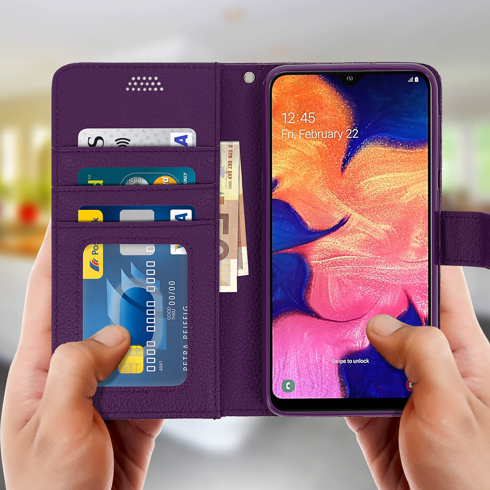 Handen houden een paarse telefoonhoes vast met kaarten, contant geld en telefoon.