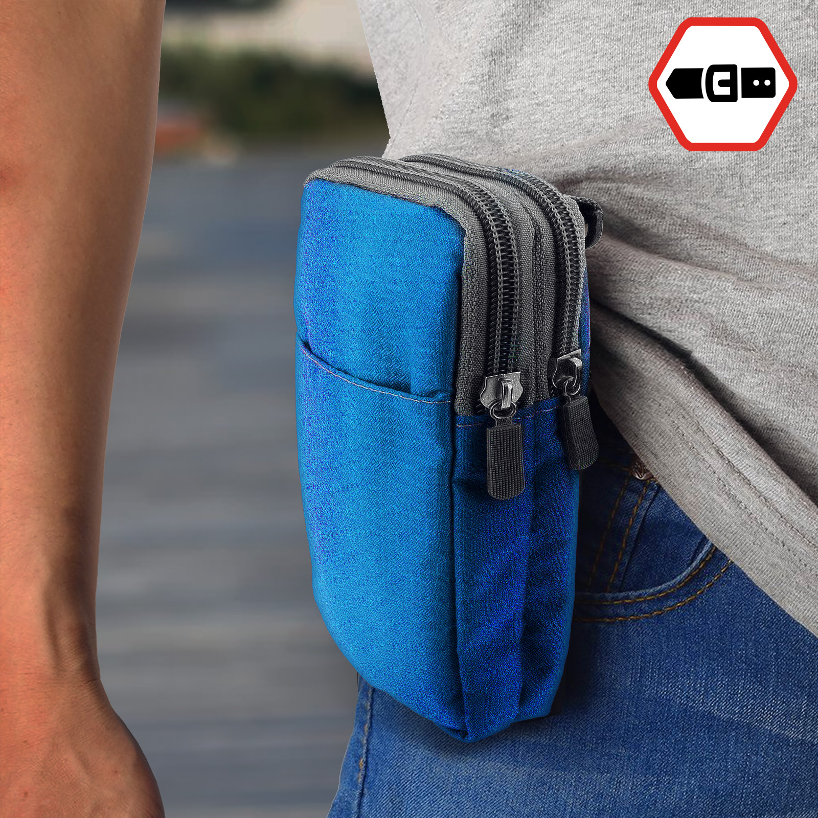 Persona che indossa una camicia grigia con una borsa blu e grigia attaccata alla cintura. La borsa ha due cerniere.