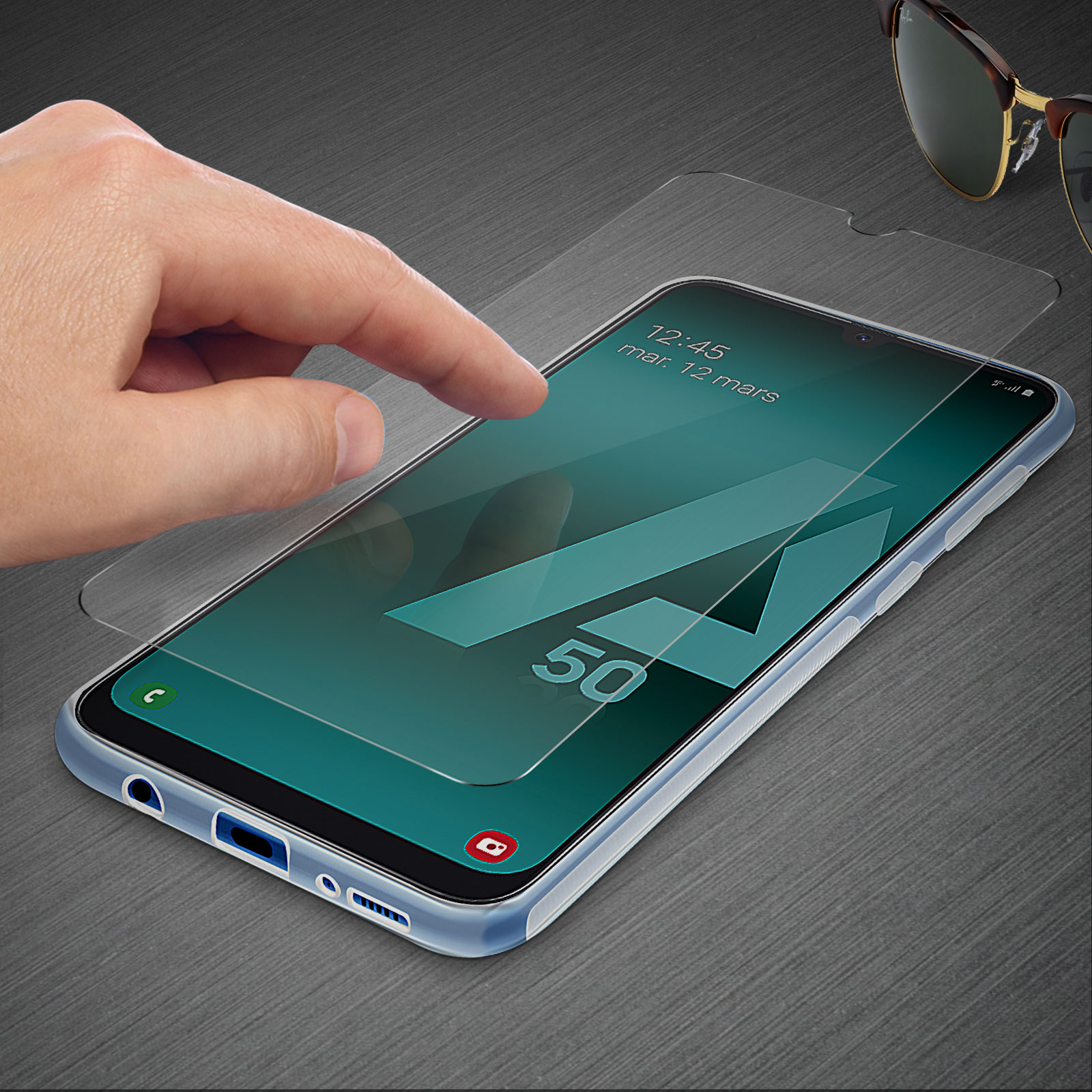 Hand berührt Telefonbildschirm mit Schutz, Sonnenbrille im Hintergrund.