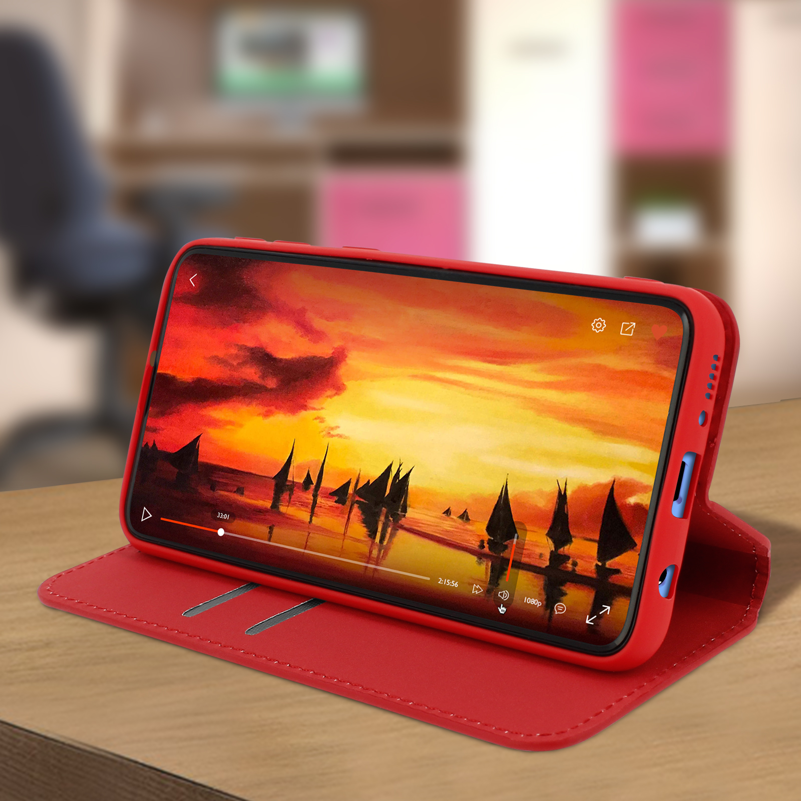Telefoon speelt video af op een tafel. Rode hoes, met een rood leren oppervlak.