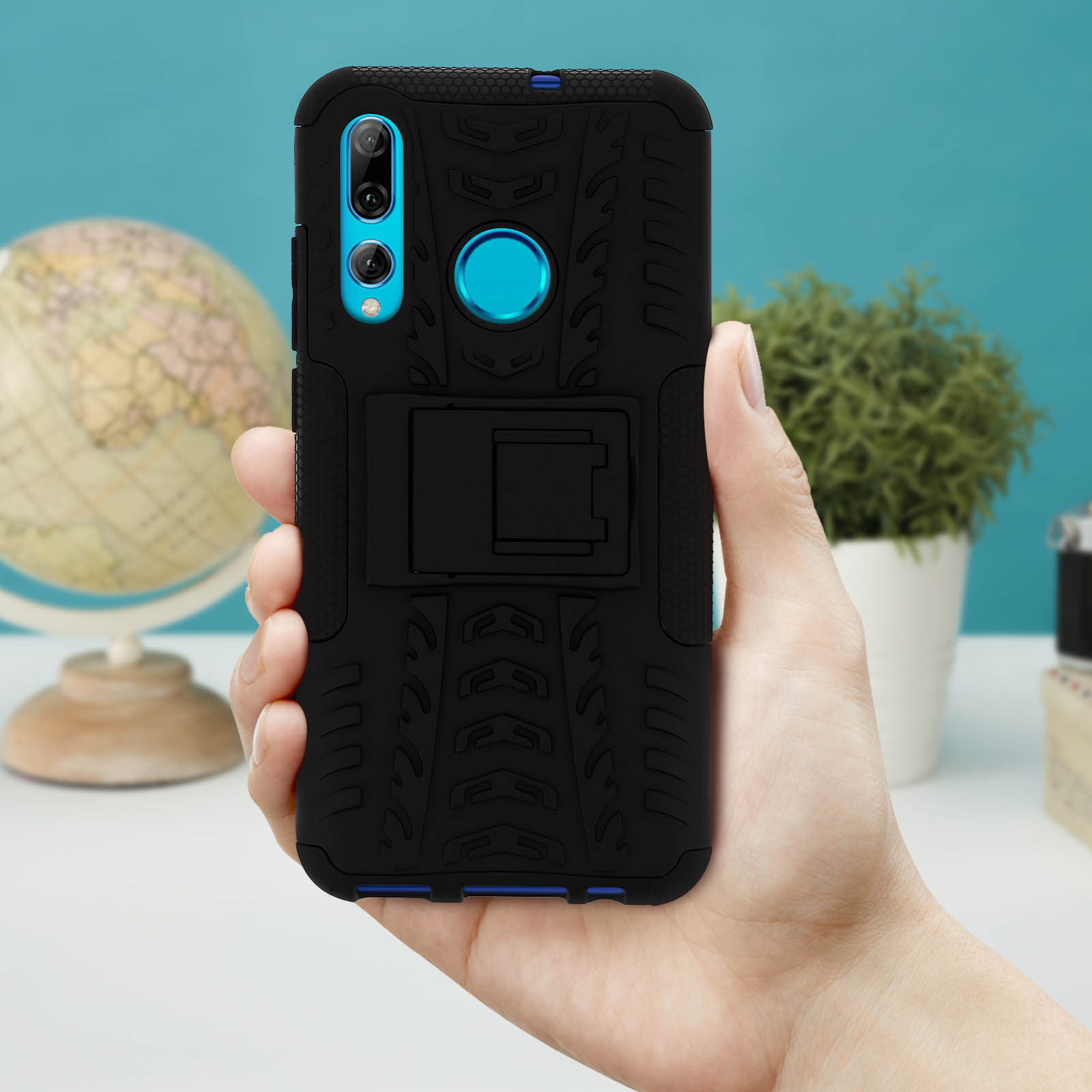 Coque de téléphone noire avec béquille. Tenue par une main sur fond bleu.