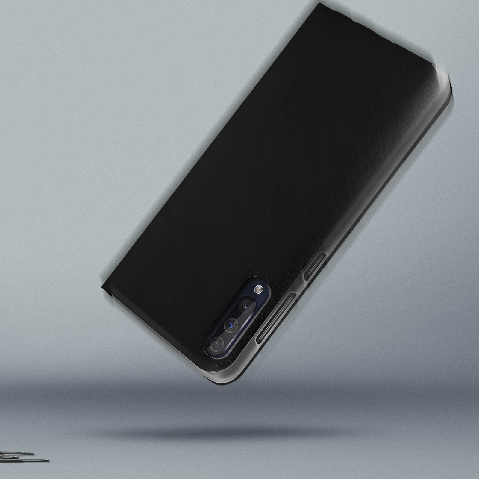 Zwarte telefoonhoes met drievoudige camera op een grijze achtergrond. De hoes staat schuin.