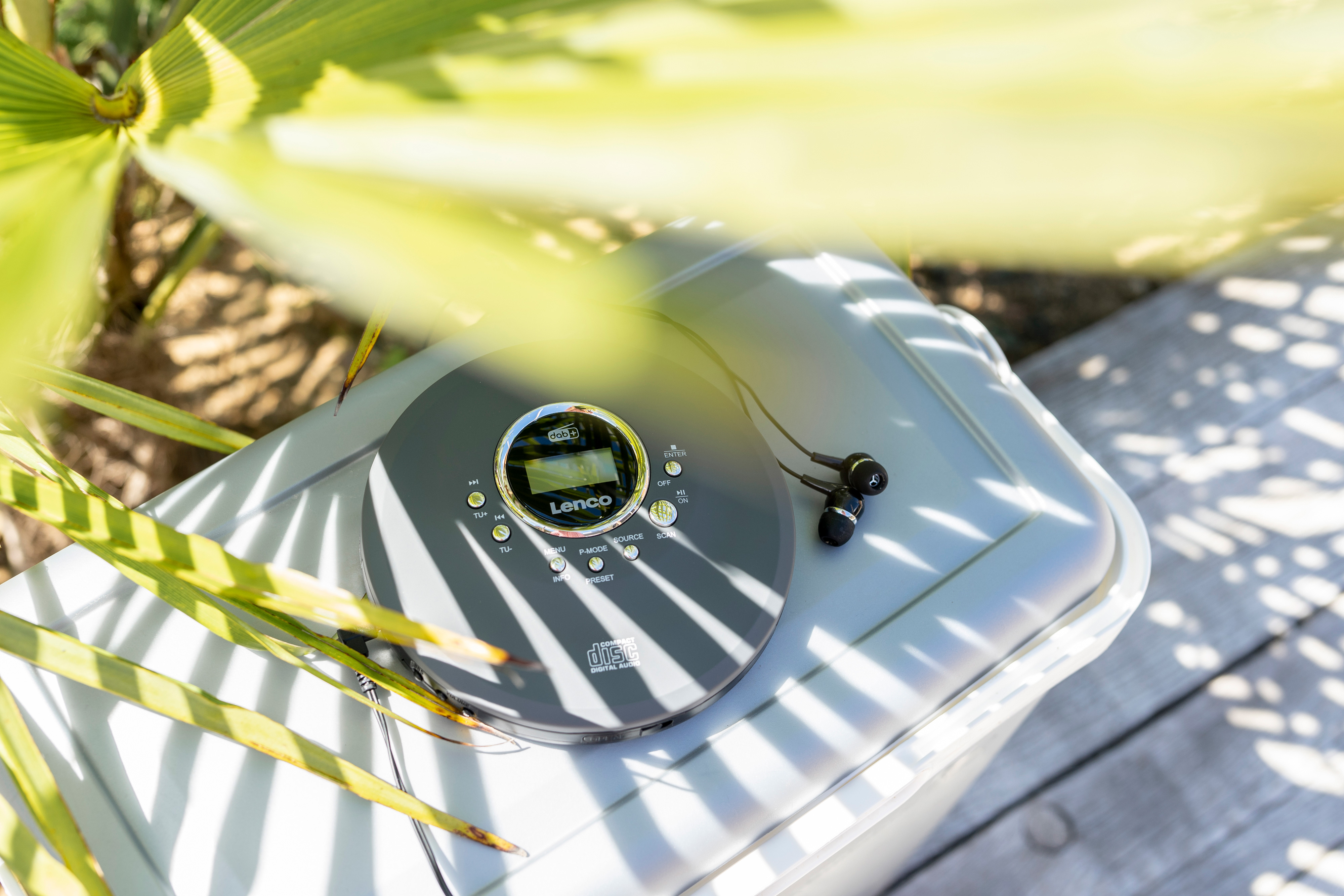 Przenośny odtwarzacz CD i słuchawki na szarym pojemniku.