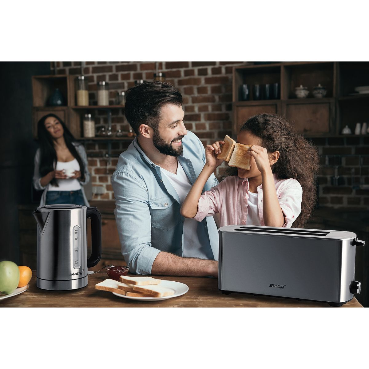Eine Familie in einer Küche. Ein Mann und ein Mädchen spielen mit Toast.