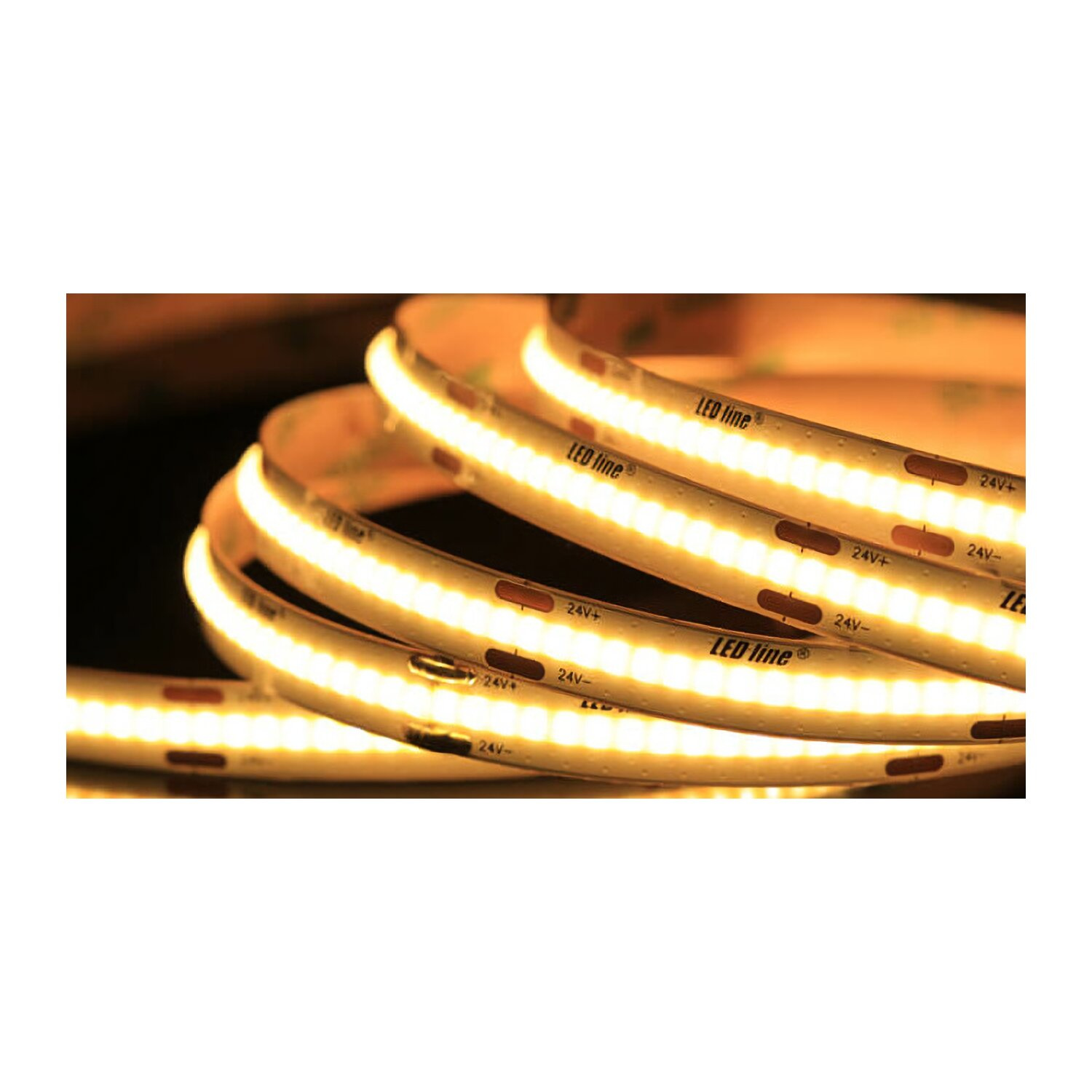 Gerollte LED-Lichtstreifen, beleuchtet mit warmem Licht, auf dunklem Hintergrund.