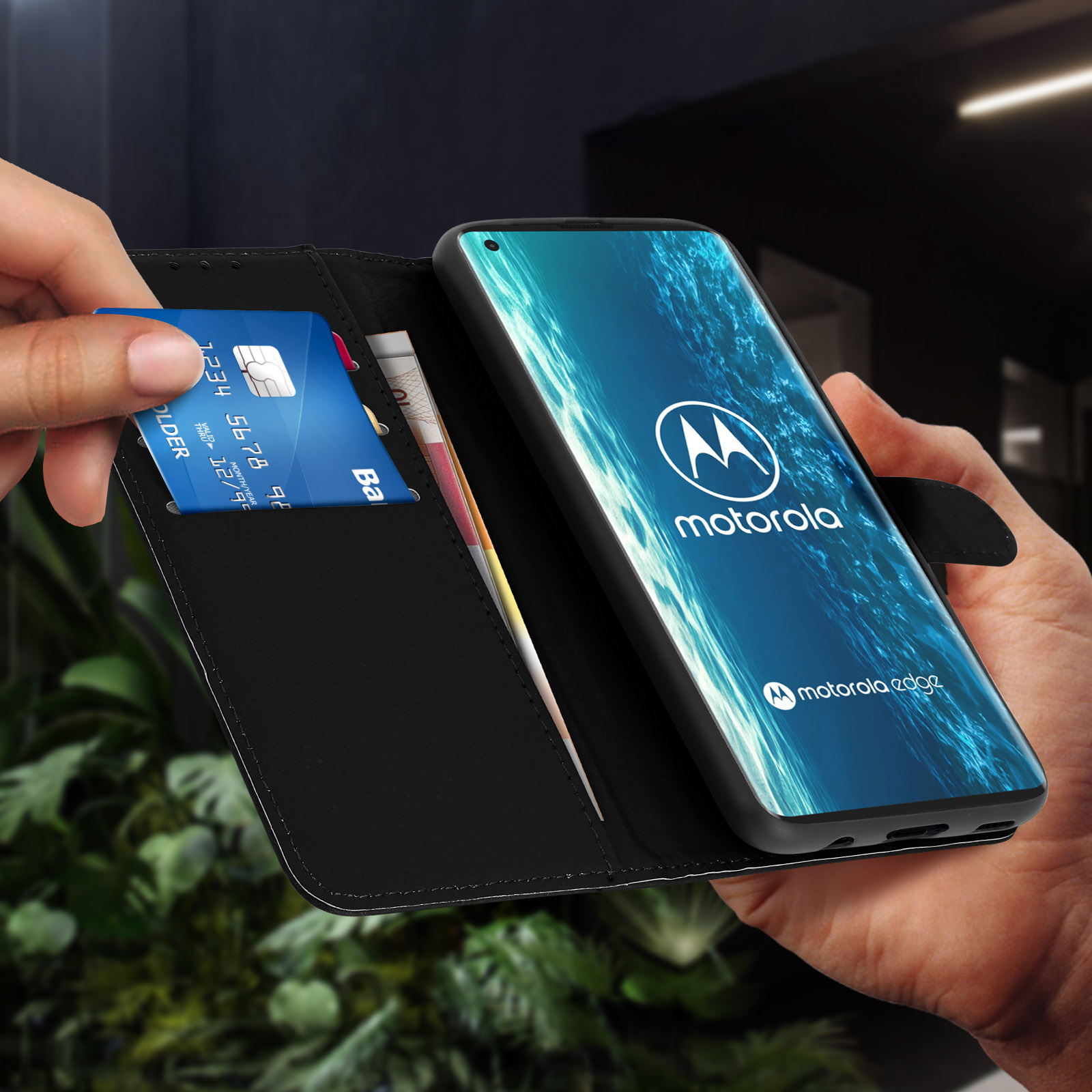 Mano che apre un portafoglio, rivelando una carta di credito e banconote. Un telefono sullo sfondo.