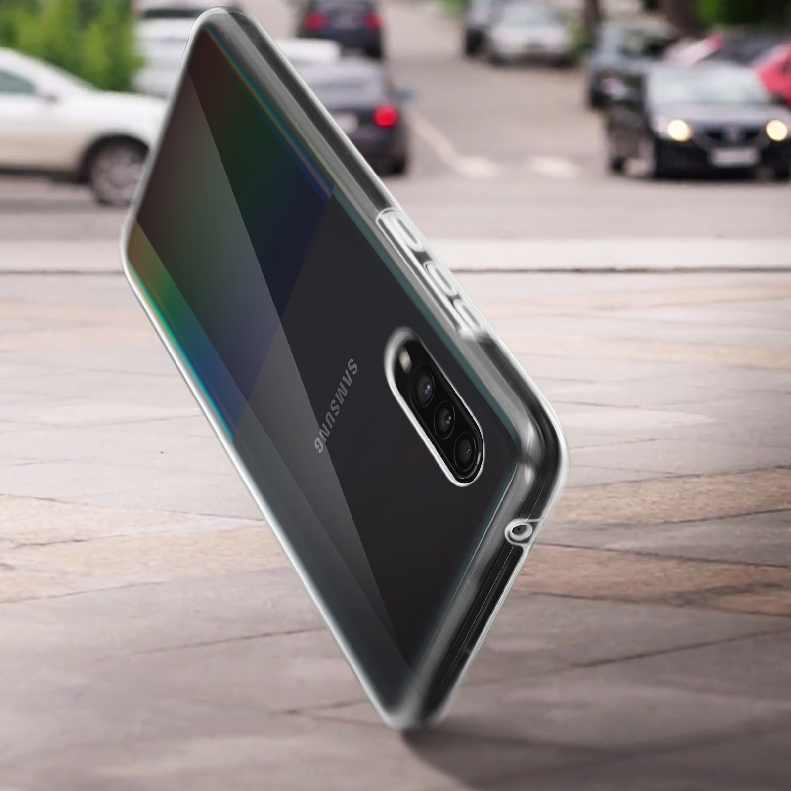 Telefono nero in custodia trasparente per strada. Il telefono ha una fotocamera. Sfondo sfocato.