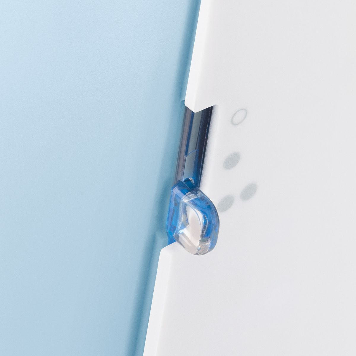 Nahaufnahme eines blauen Scharniers auf weißer Oberfläche vor blauem Hintergrund.