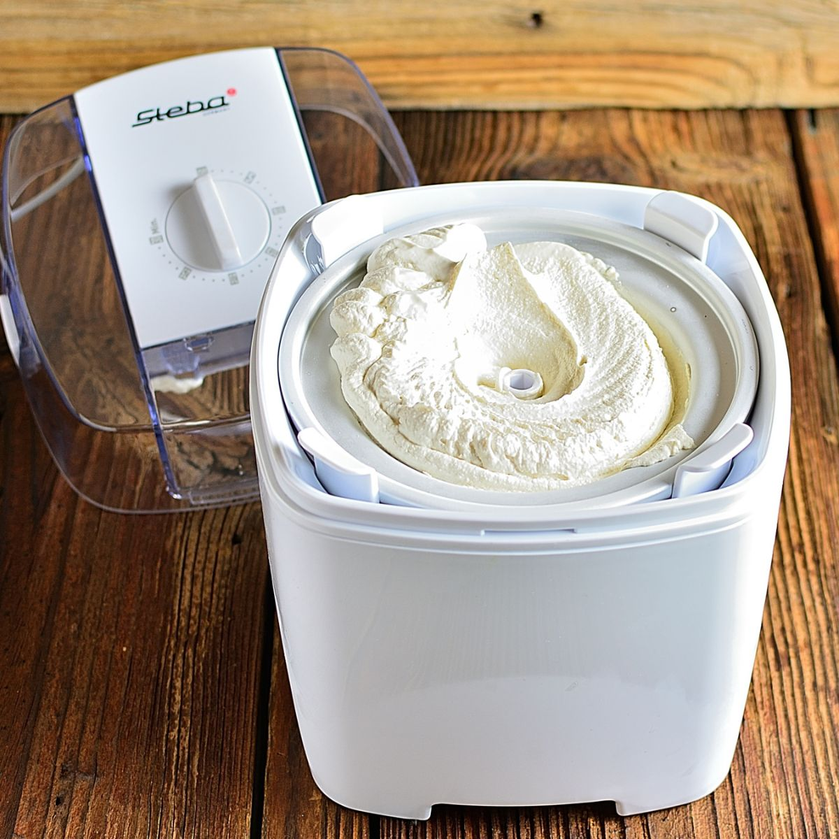 Gelatiera bianca con gelato dentro. Coperchio trasparente sopra.