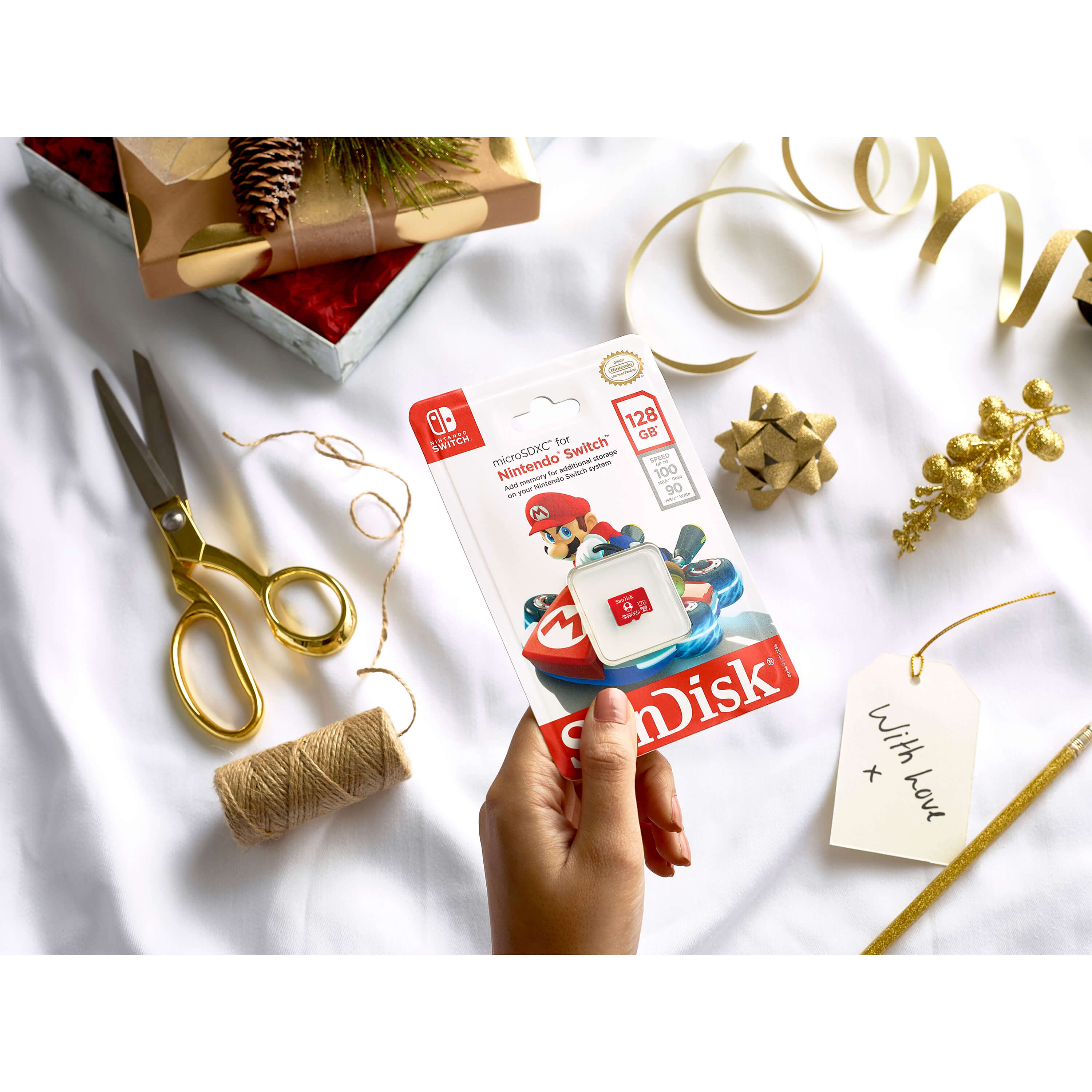 Una mano tiene una custodia per schede di gioco Nintendo Switch. Include un regalo, forbici e nastro.
