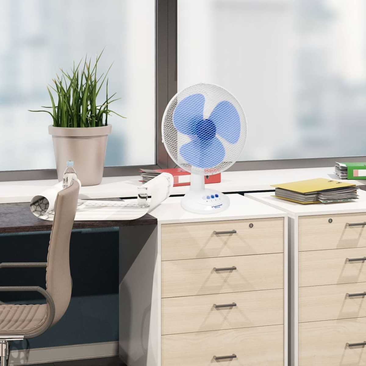 Biało-niebieski wentylator na biurku. Środowisko biurowe z roślinami i oknem.