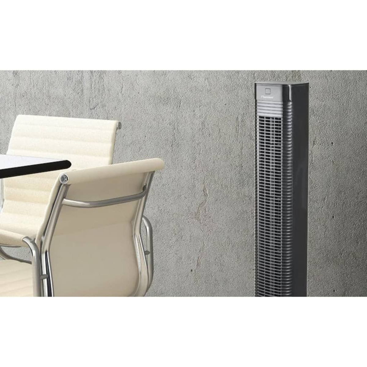 Purificatore d'aria alto nero e grigio vicino a tavolo e sedie in una stanza.