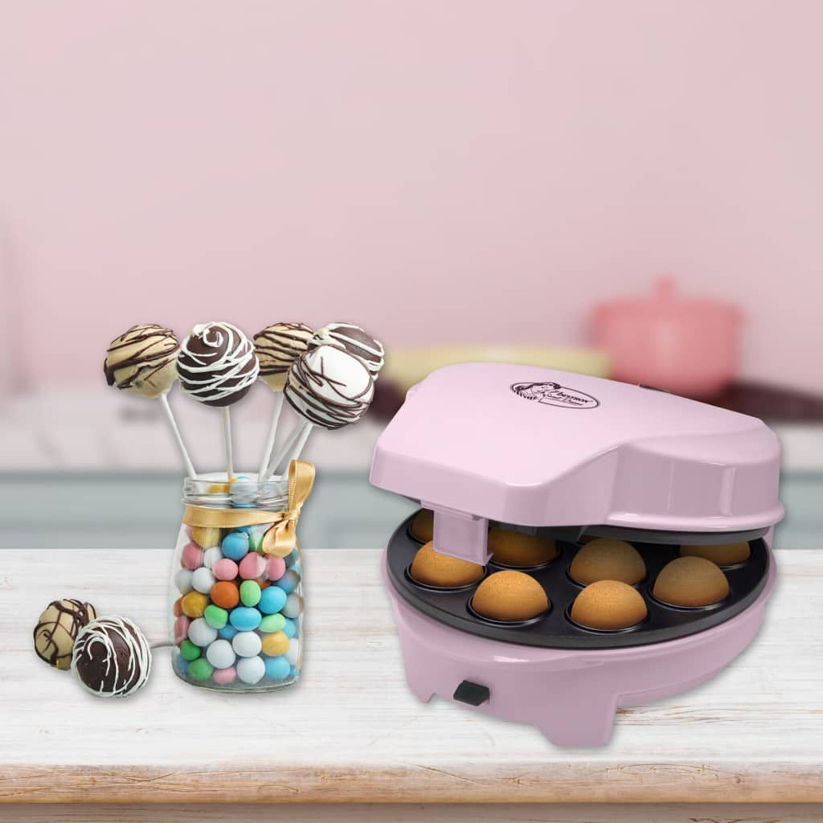 Ein rosa Cake-Pop-Maker mit Cake-Pops und Süßigkeiten in einem Glas.