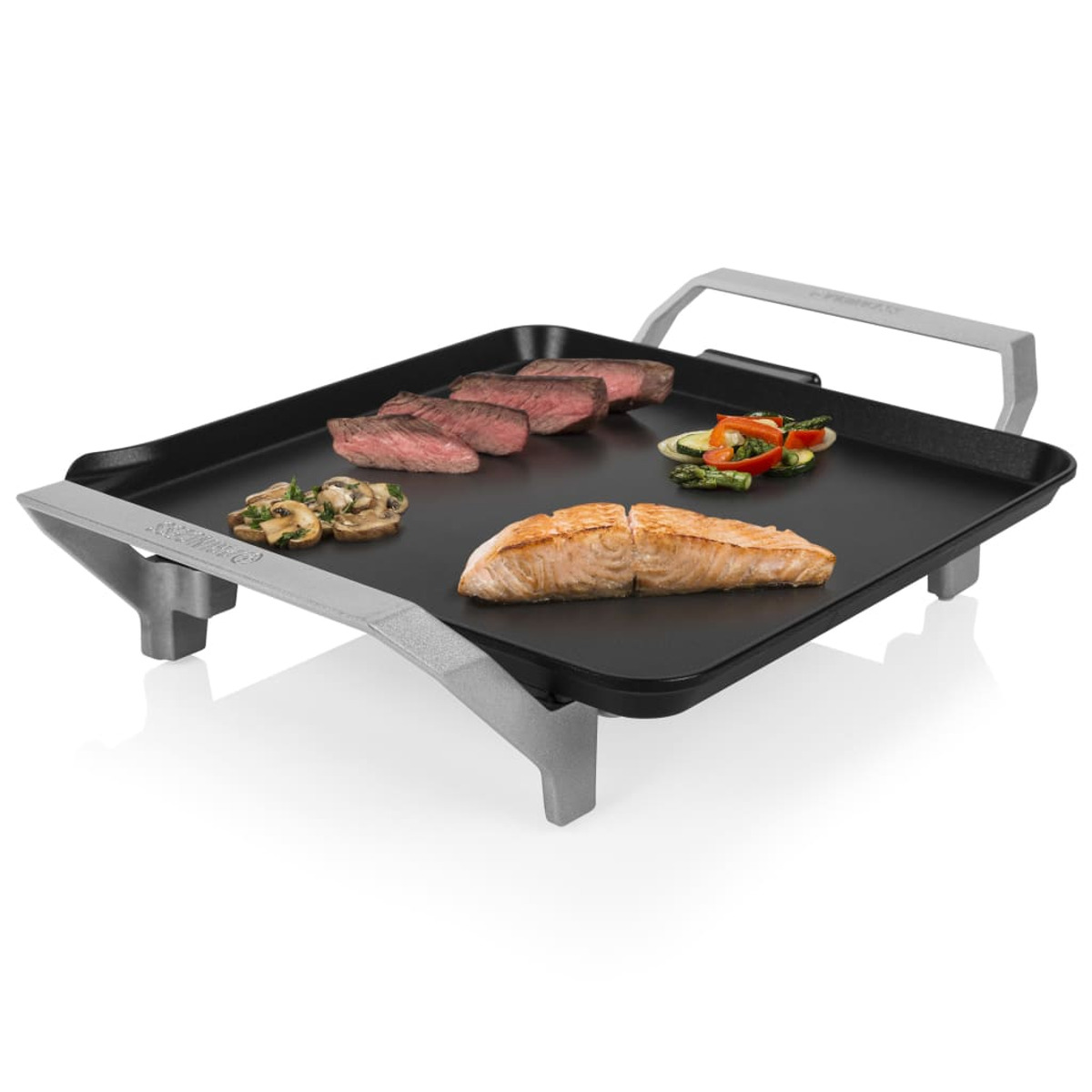 Parrilla negra con alimentos cocinados. Filete, salmón, champiñones y verduras están en la parrilla.