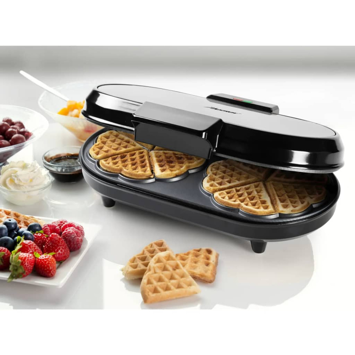 Máquina para hacer gofres con gofres y frutas. Fondo blanco.