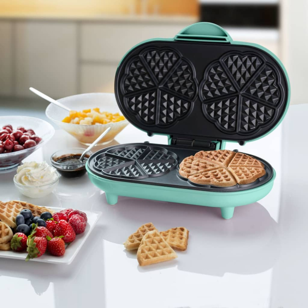 Miętowy gofrownica z upieczonymi goframi i różnymi dodatkami.