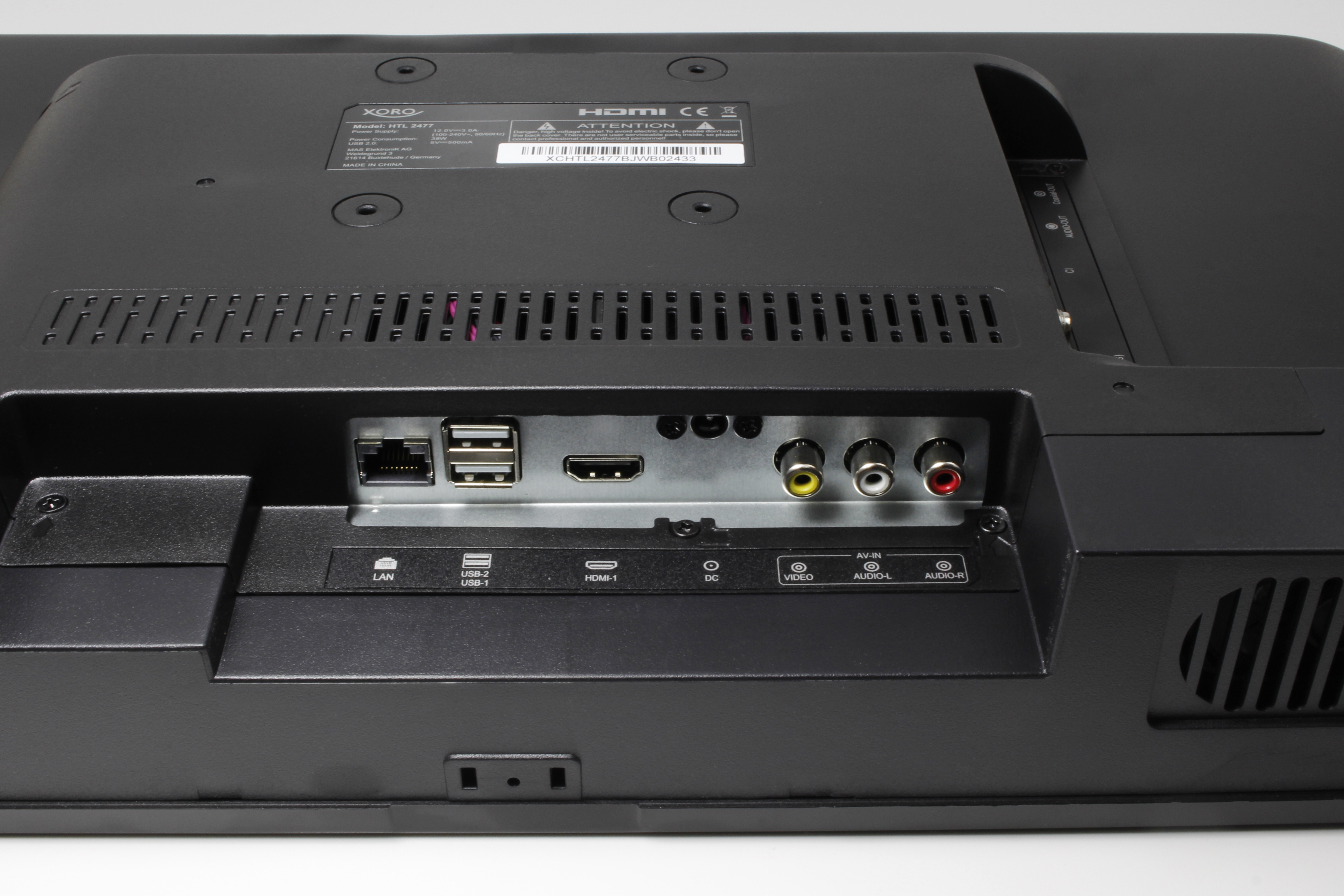 Tył czarnego telewizora z portami, w tym HDMI, USB i wyjściami audio.