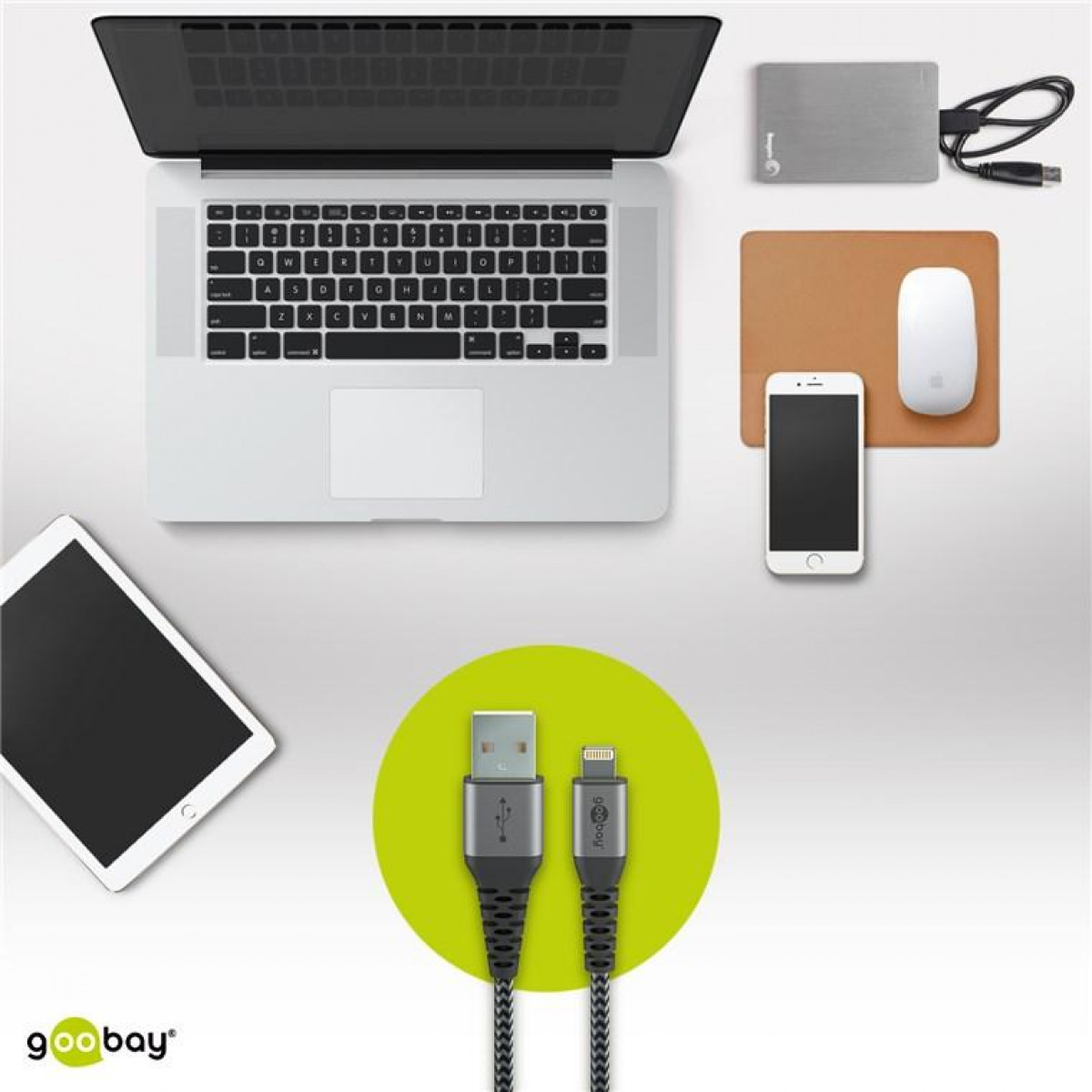 Laptop, Tablet, Telefon, Maus und Ladekabel auf einer Oberfläche. Die Kabel sind von Goobay.