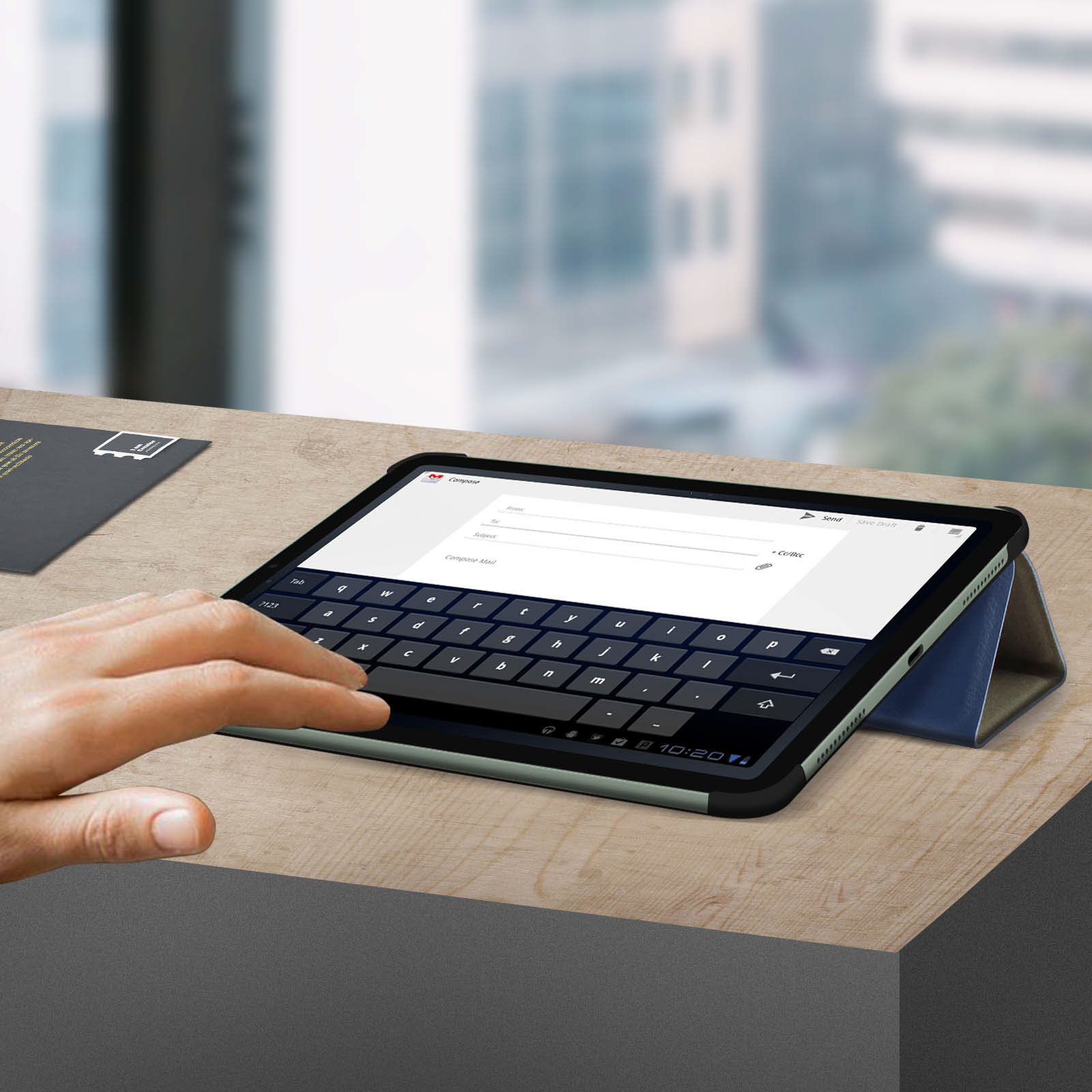 Una mano tocca un tablet con una tastiera sullo schermo.