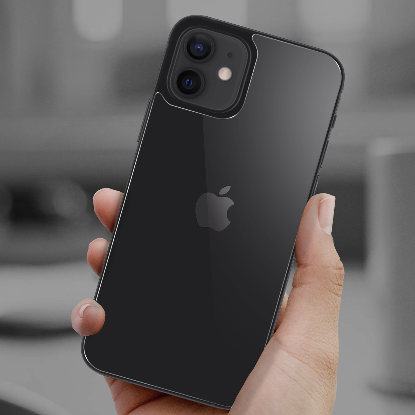 Telefono nero tenuto in mano, vista posteriore, con logo Apple visibile.
