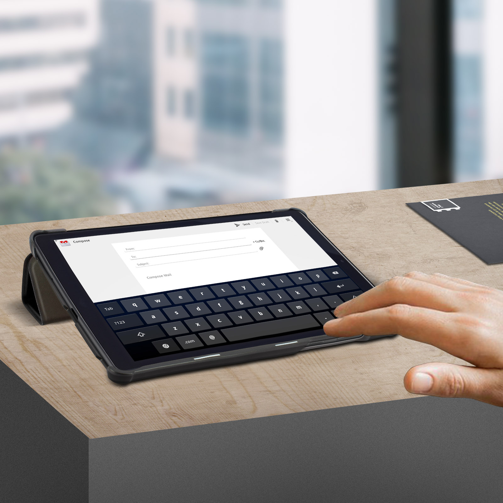Un tablet con custodia con tastiera su una scrivania. Una mano tocca lo schermo.