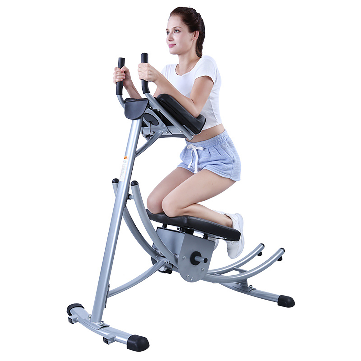 Woman on an exercise machine. She holds handles with hands and knees on a seat.