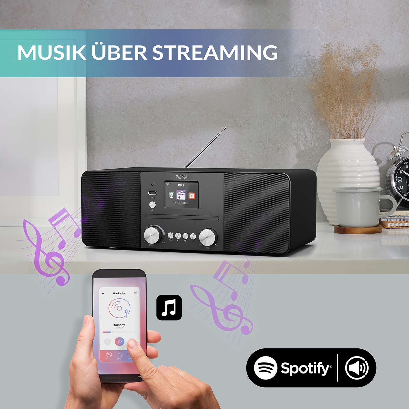 Czarne radio strumieniujące muzykę. Telefon wyświetla muzykę z logo Spotify.