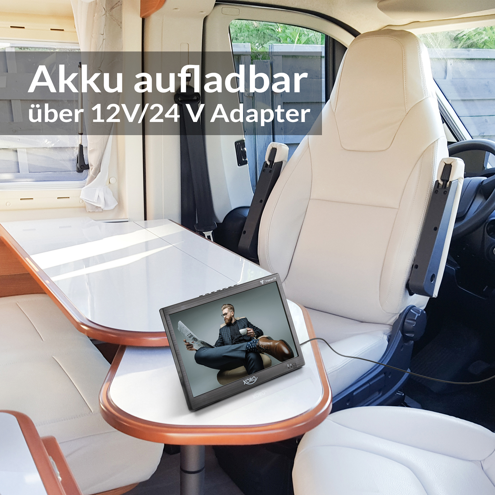 Ein Mann sitzt in einem Wohnmobil und schaut auf einen Bildschirm. Ein Tisch ist vor ihm.