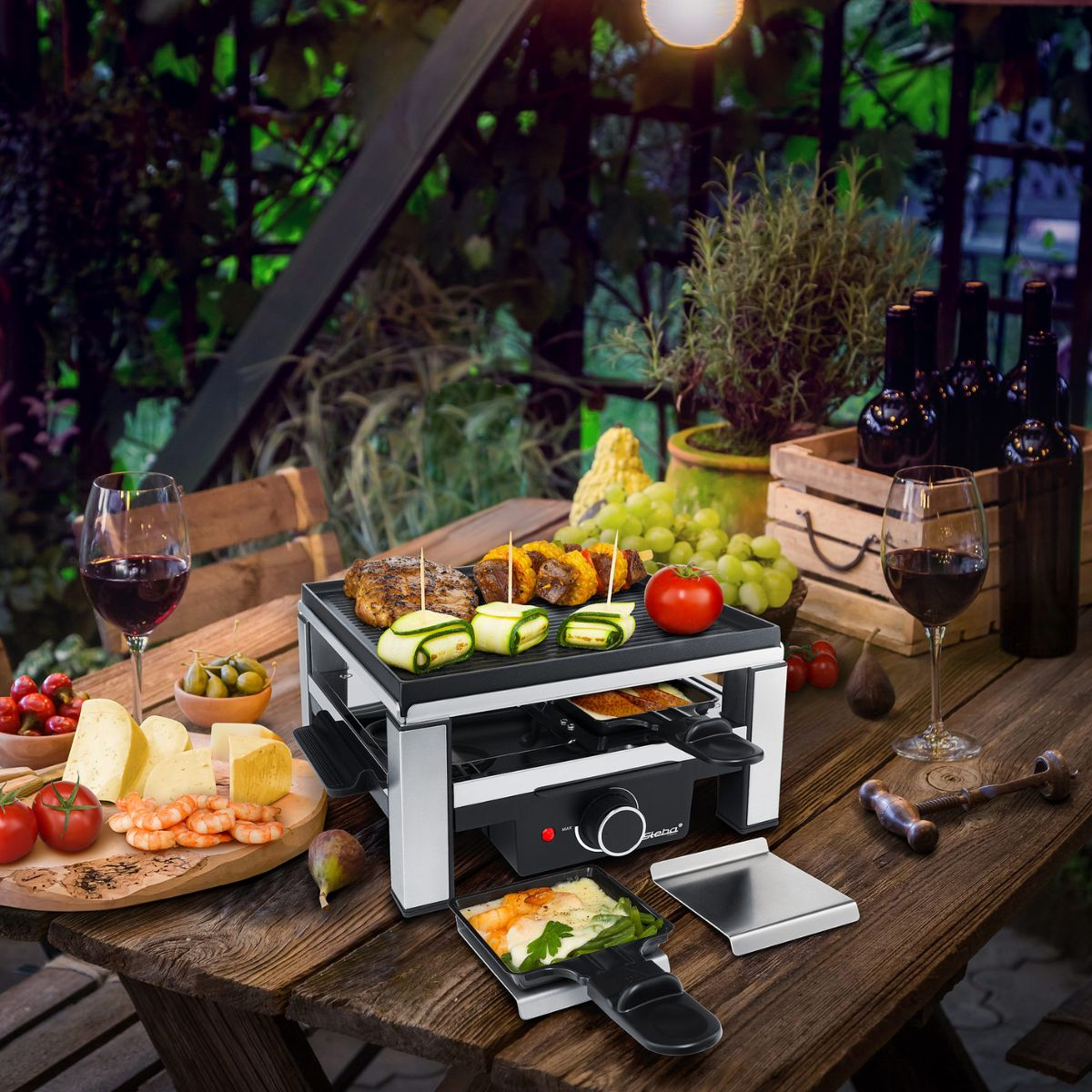 Grill per raclette con cibo, calici e tavola all'aperto.