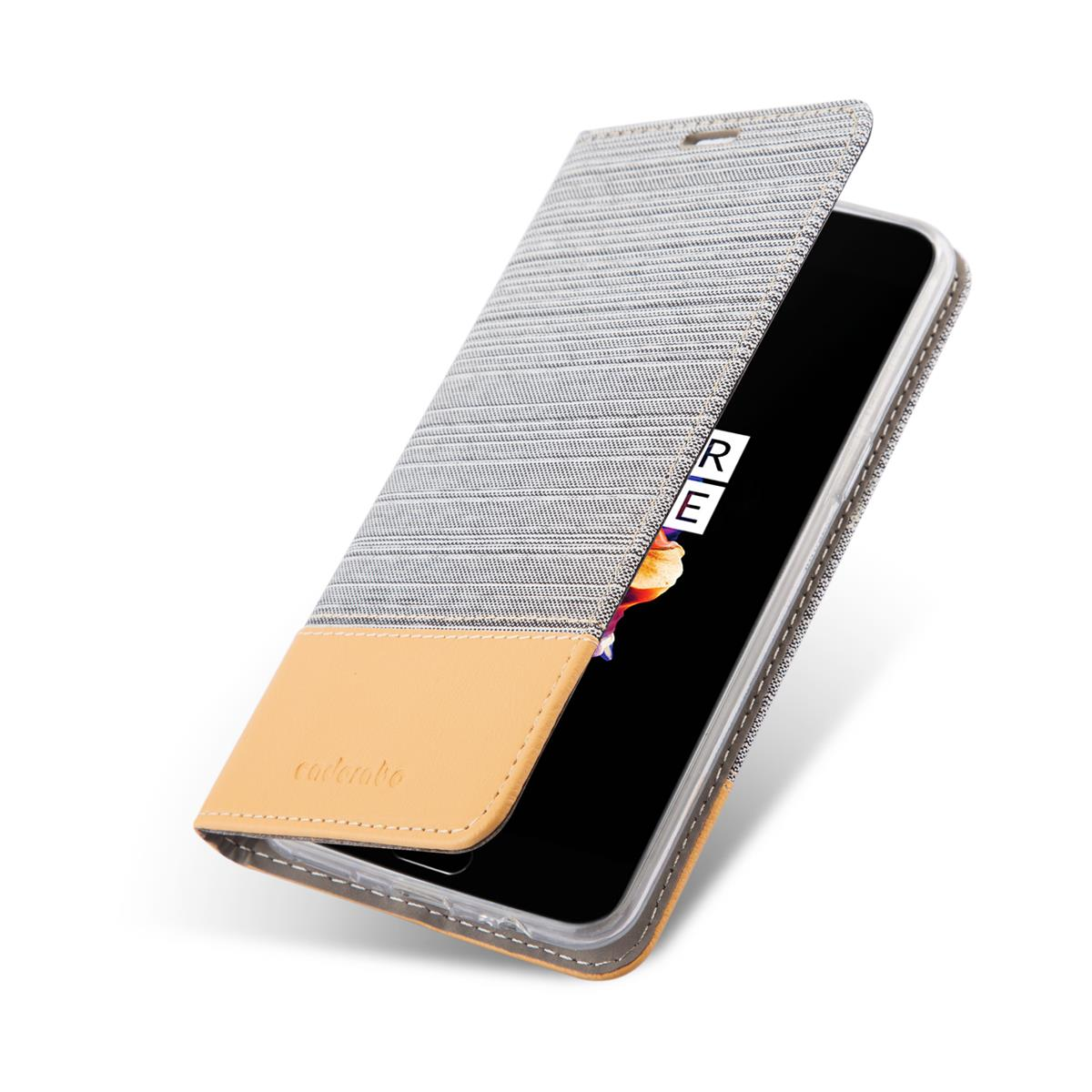 Ein Telefon in einem grauen und beigen Etui, offen. Das Etui hat das Wort „cadambo“ darauf. Weißer Hintergrund.