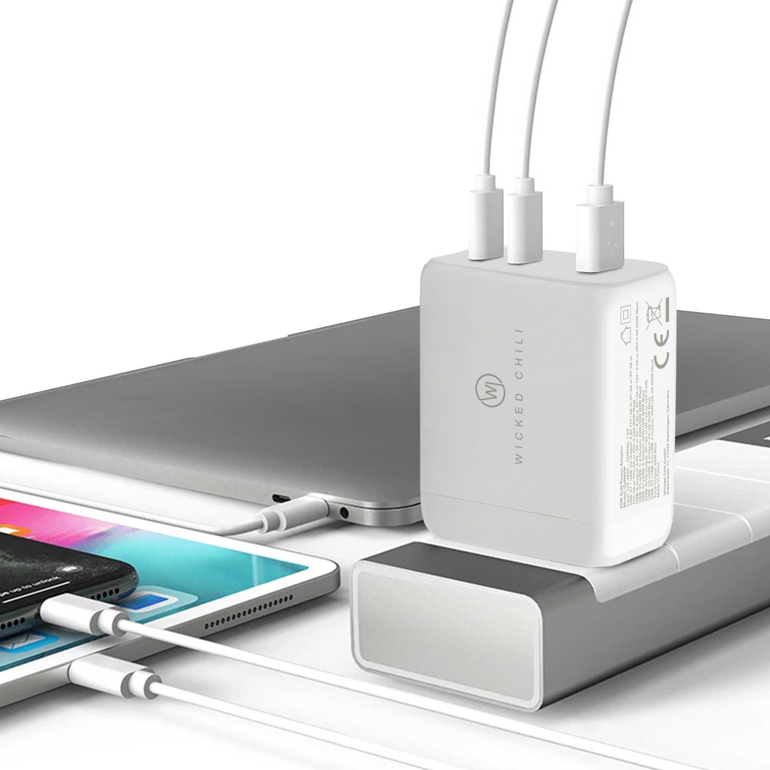 Ein weißes Ladegerät mit drei USB-Anschlüssen, angeschlossen an einen Laptop und andere Geräte.