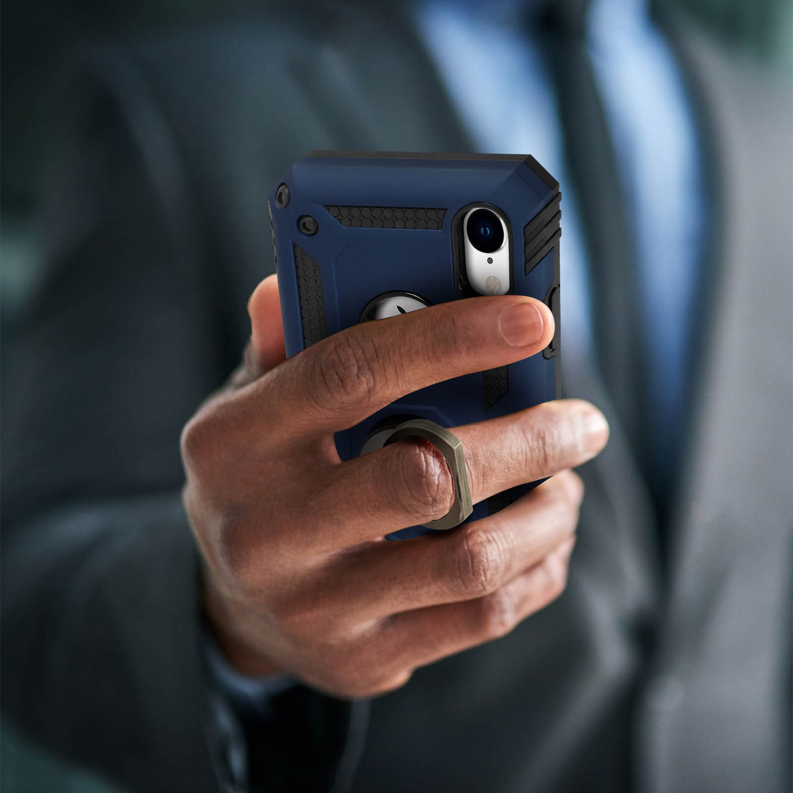 Een hand die een telefoon met een hoesje vasthoudt, met een ring op de achterkant.